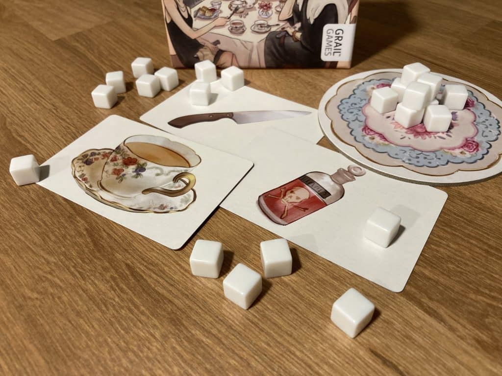 Elevenses: The Guilty Party board game showing the Guilt cards: one with a teacup, one with a bottle of poison, and one with a knife.
