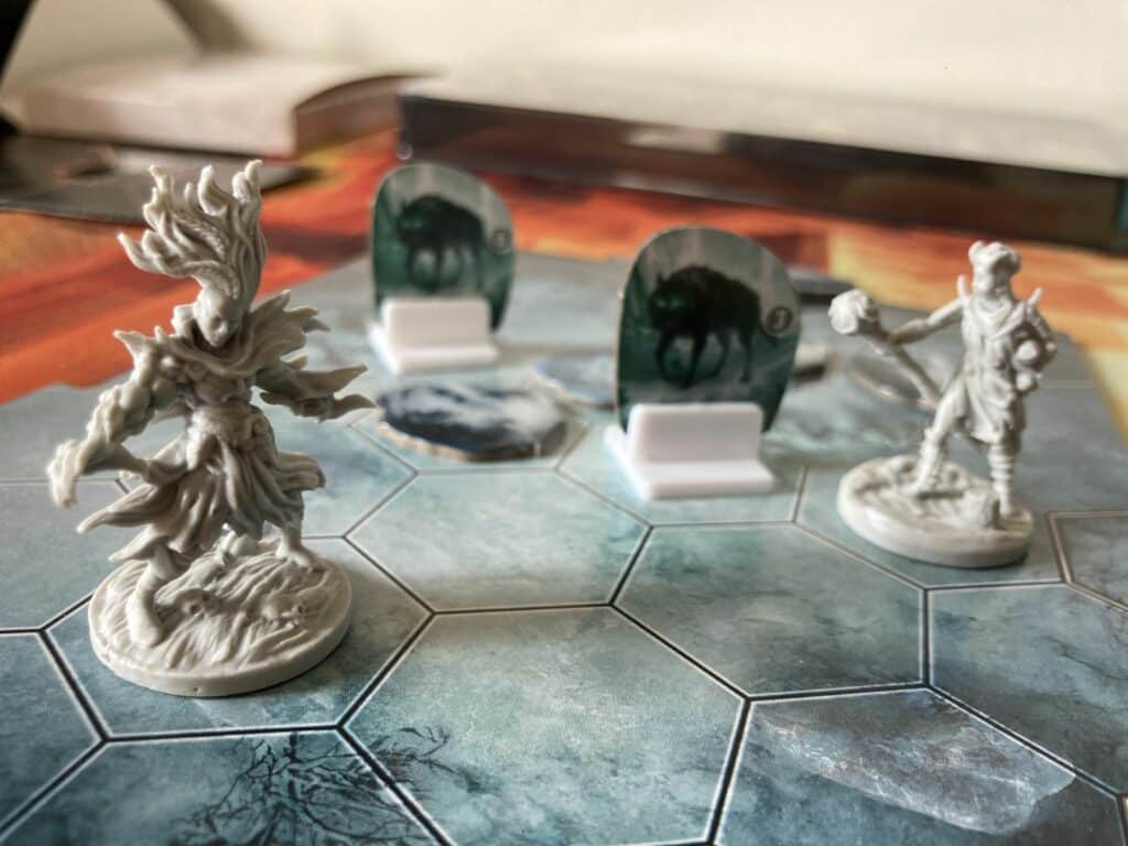 Frosthaven board game miniatures engaged in a battle with two wolves